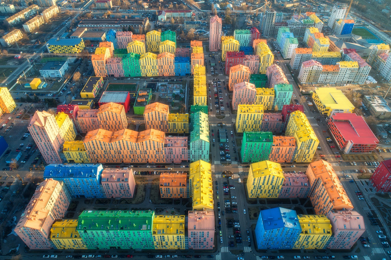 aerial-view-of-the-colorful-buildings-in-european-city-at-sunset-cityscape-with-multicolored-houses-cars-on-the-street-in-kiev-ukraine-top-view-urban-landscape-aerial-photo-of-a-downtown